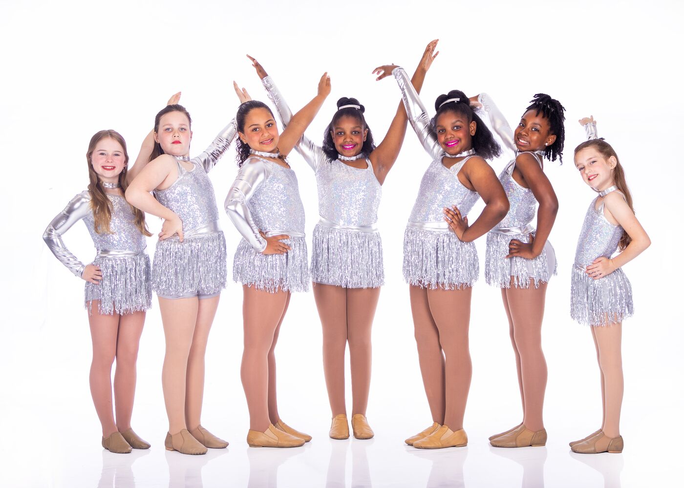 Dancers in silver fringe costumes striking a pose