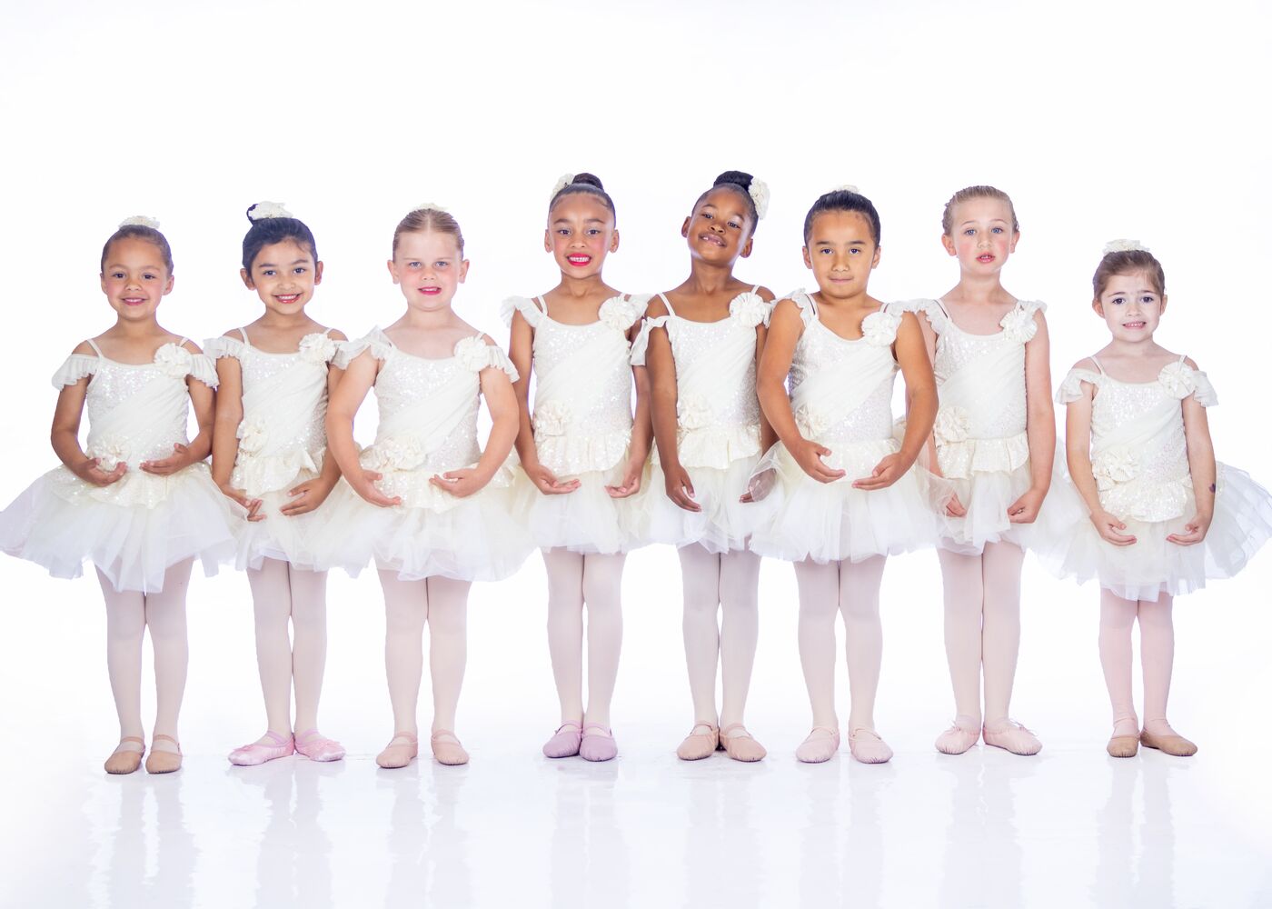 Little ballet dancers in white tutus standing in a line