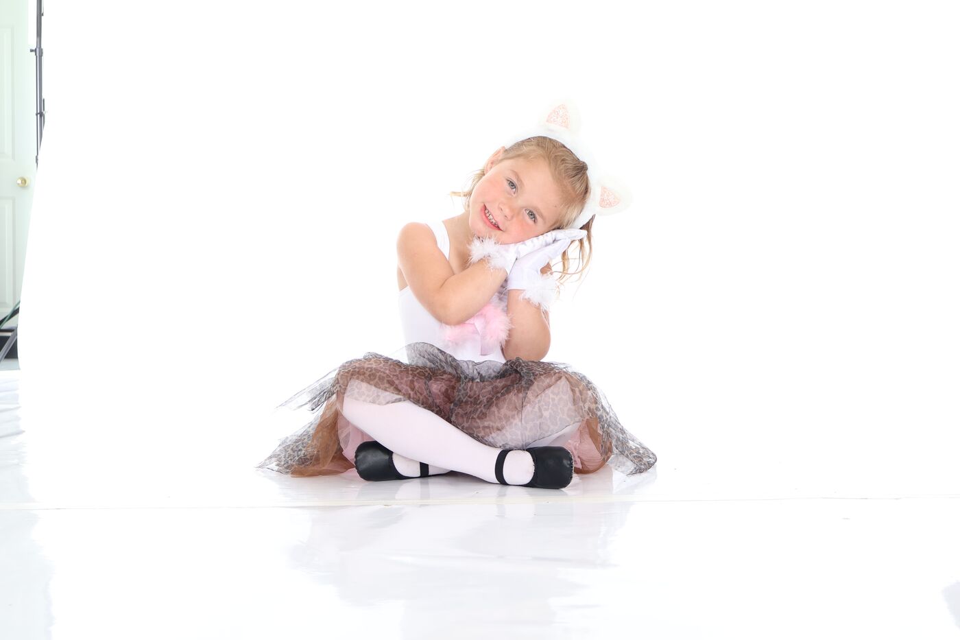 A young dancer sitting with her hands under her chin